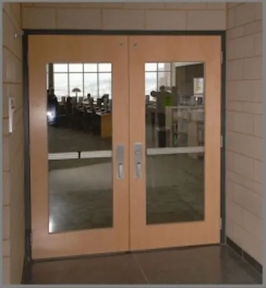 Wood double doors with large glass panels in a dark frame