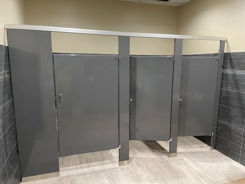 Gray restroom partition bank with overhead bracing