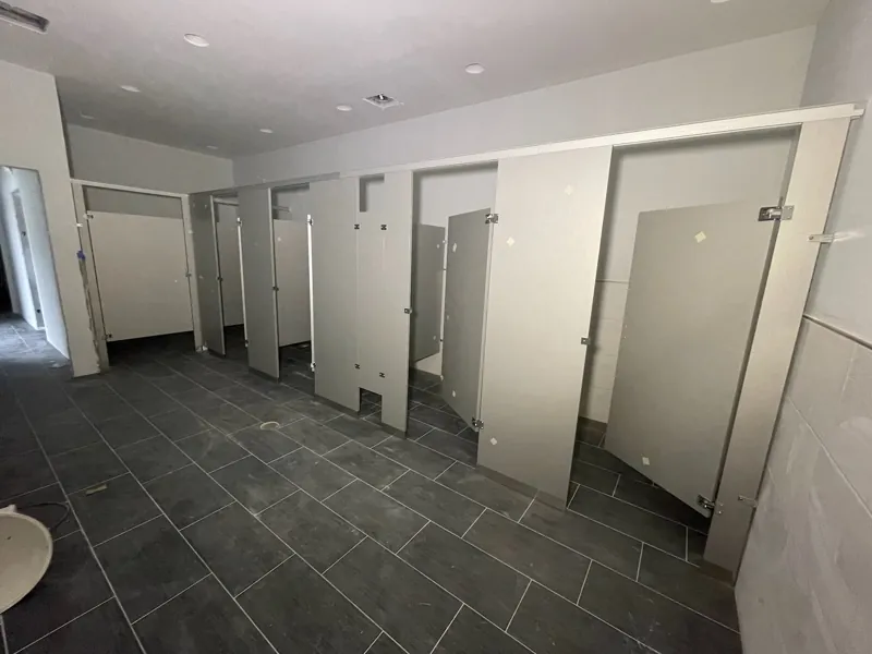 Gray partitions arranged in a multi-stall restroom