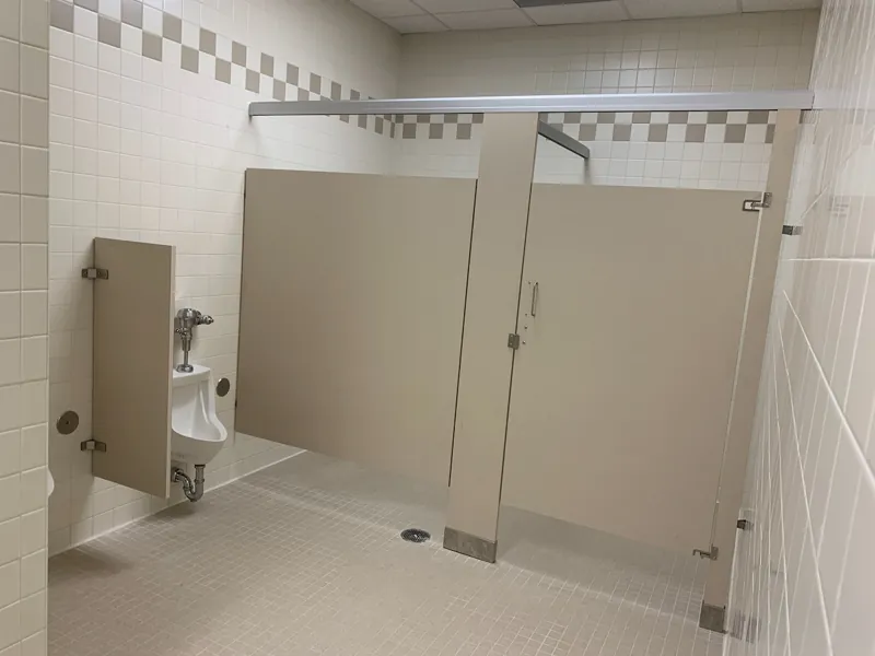 Beige restroom compartments beside decorative wall tile